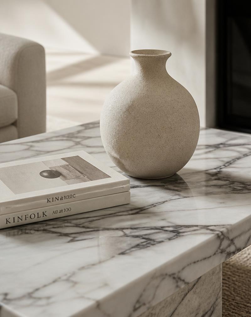 Marble coffee table styled with a ceramic vase and art books